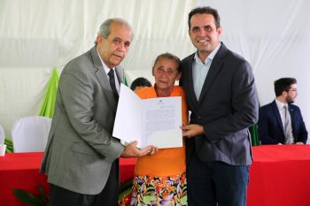 Moradora Rita dos Santos recebeu o título das mãos do desembargador Celyrio Adamastor e do prefeito Geraldo Filho. Foto: Caio Loureiro.